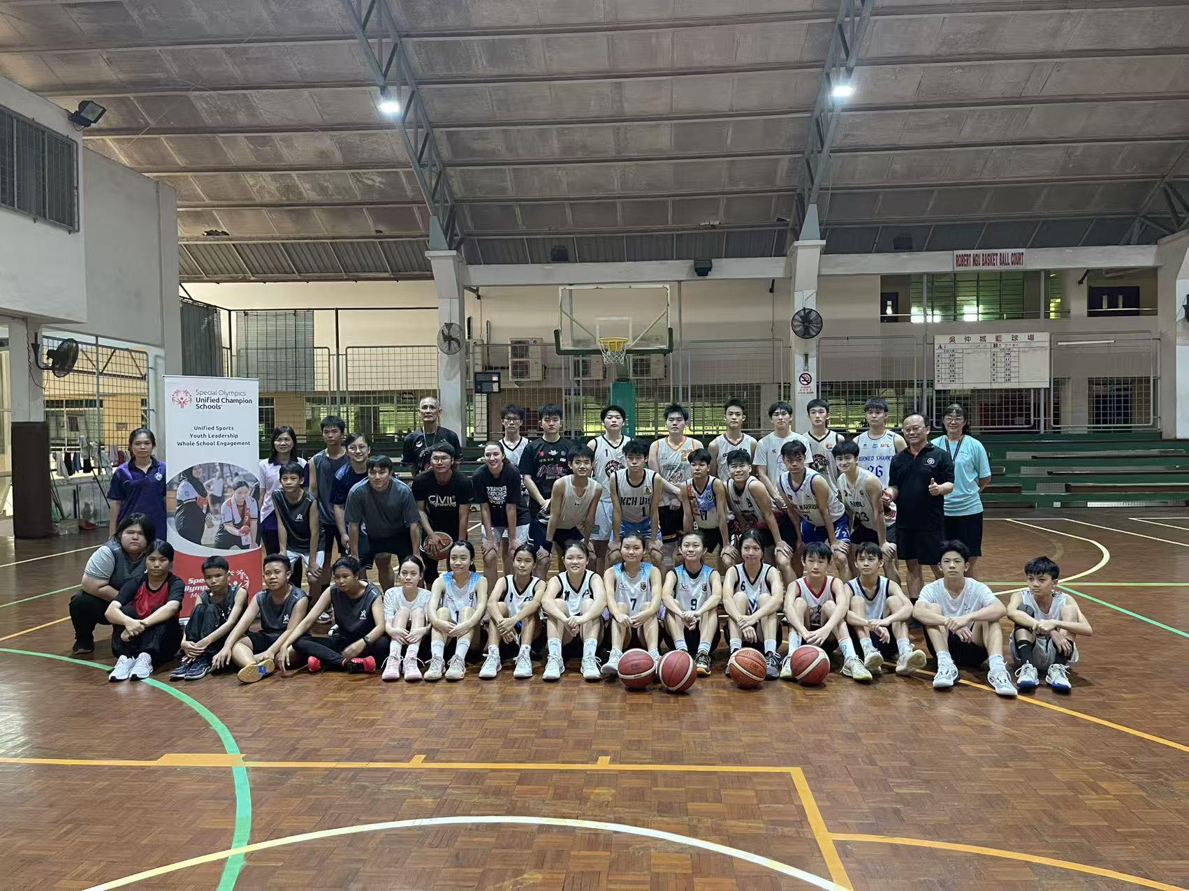 Unified sports team of athletes with and without disabilities playing basketball together, showing teamwork and camaraderie