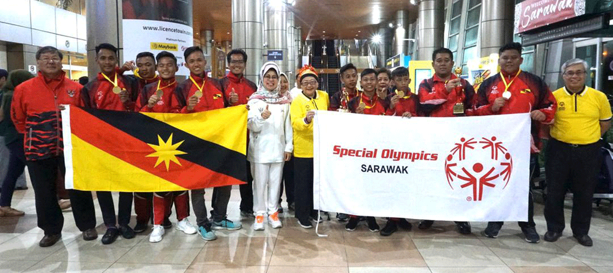 Group of Special Olympics athletes participating in various sports activities with coaches and volunteers